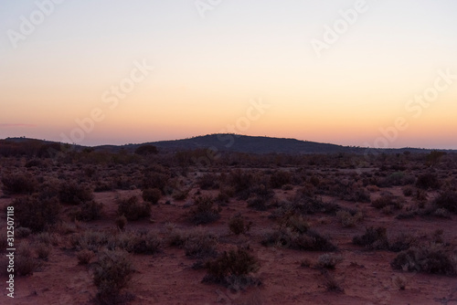 The small hills in desert of Broken Hill outback of New South Wales, Australia at Morning sunrise orange sky.