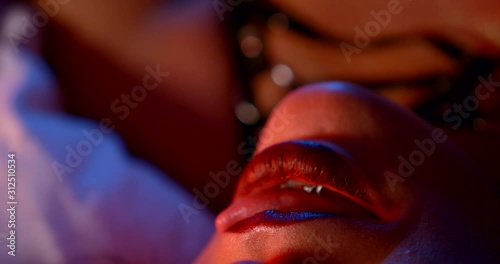 woman is licking lips passionately lying in bedroom, wearing lingerie