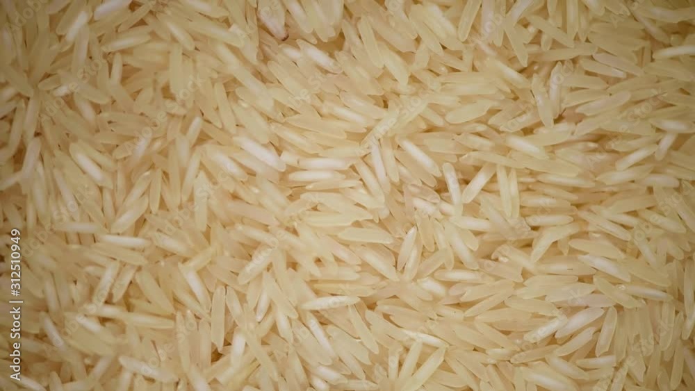 White raw organic basmati rice rotation background. Food ingredient background. Top view, healthy lifestyle concept. White raw organic basmati rice rotation background. Food ingredient background. Top view, healthy lifestyle concept.