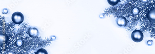 Christmas classic silver and blue decoration baubles and fir tree branches on white banner background of many wooden planks with copy space for text. Rustic holiday and new year concept. Color of 2020