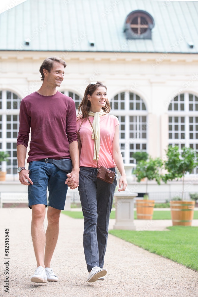 Young couple walking against buildings
