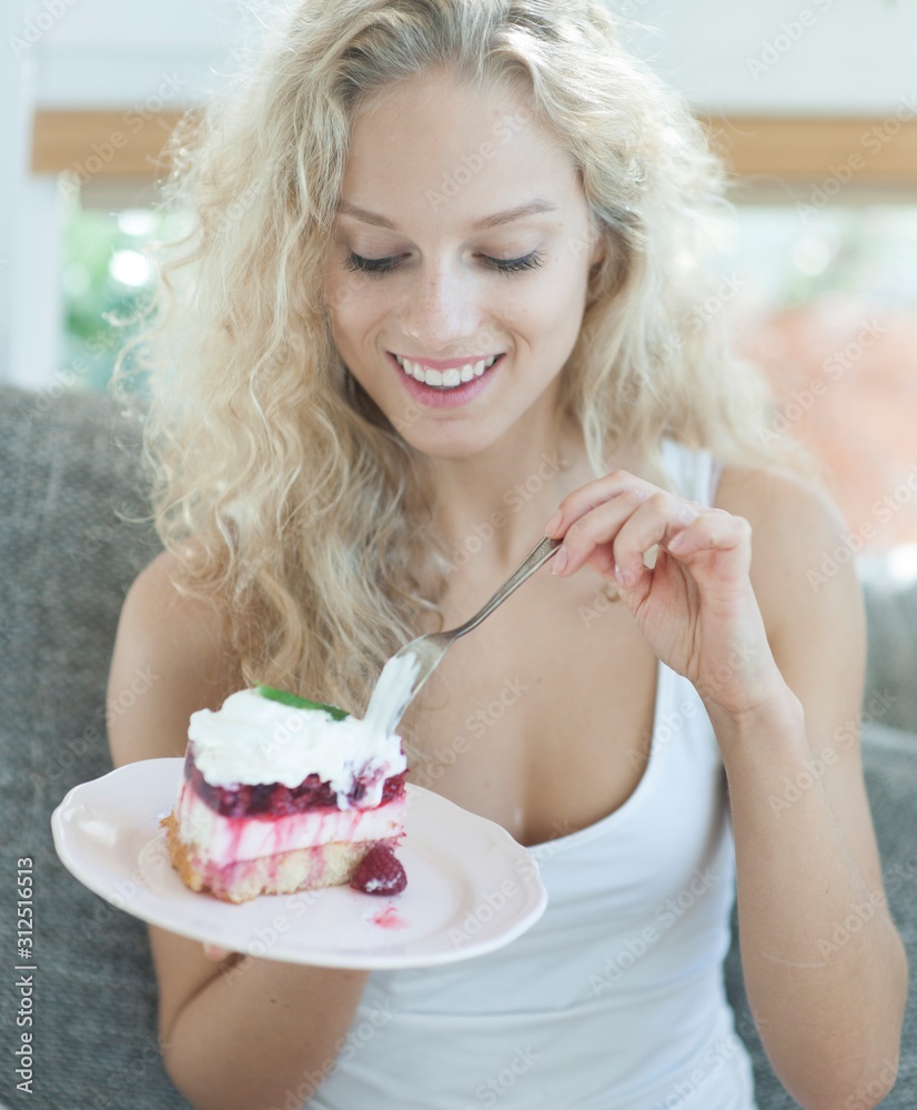Beautiful woman having raspberry cake in house Beautiful woman having raspberry cake in house