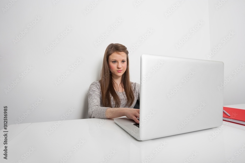 Beautiful businesswoman working on laptop at office desk Beautiful businesswoman working on laptop at office desk