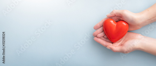 The woman is holding a red heart.