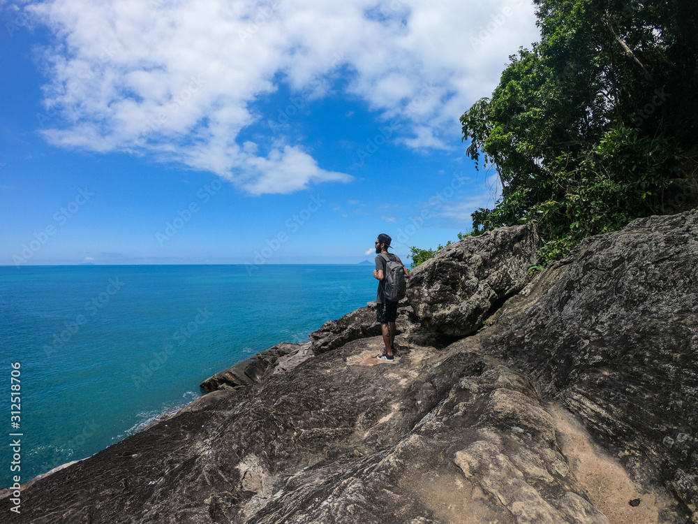 Fototapeta premium Man standing on a tropical beach cliff