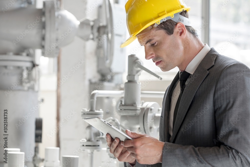 Young male supervisor using tablet PC in industry Young male supervisor using tablet PC in industry