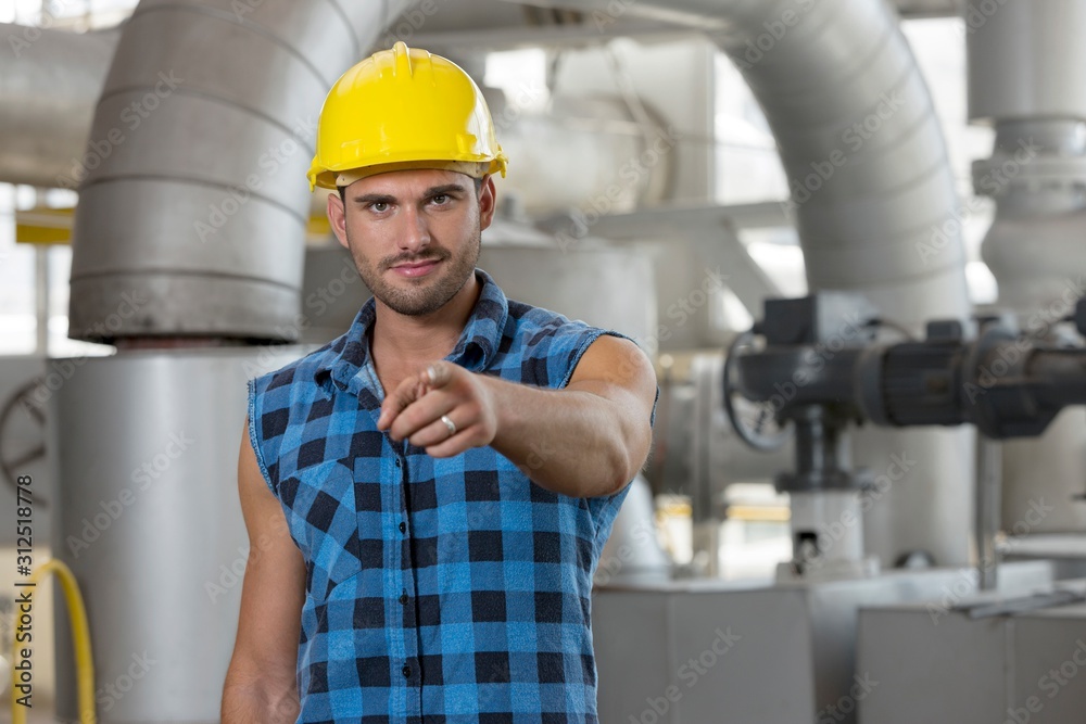 Portrait of confident young worker pointing at you in industry Portrait of confident young worker pointing at you in industry