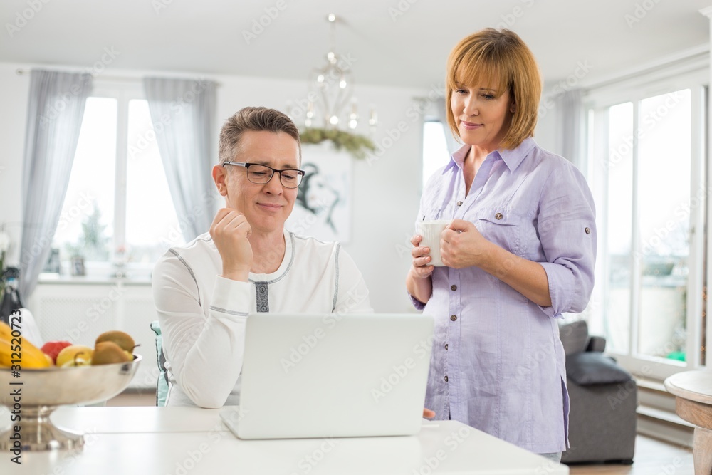 Fototapeta premium Mature couple using laptop at home