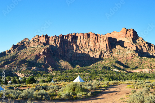 Luxurious white tents and big mountain and stone formation in desert near Zion national park