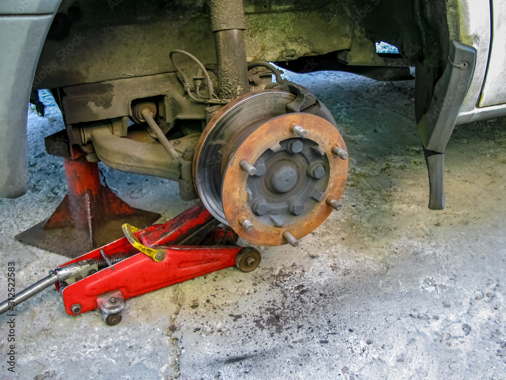 Front disc brake on car in process of new tire replacement. Front disc brake on car in process of new tire replacement.