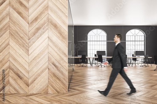 Businessman walking in wooden office