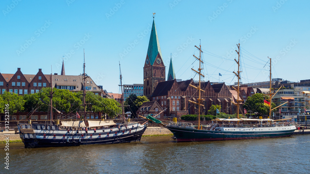 Alexander von Humboldt tall ship and others wooden sailing ships on River Weser. St. Martini church on background, Bremen, Germany