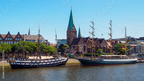 Alexander von Humboldt tall ship and others wooden sailing ships on River Weser. St. Martini church on background, Bremen, Germany