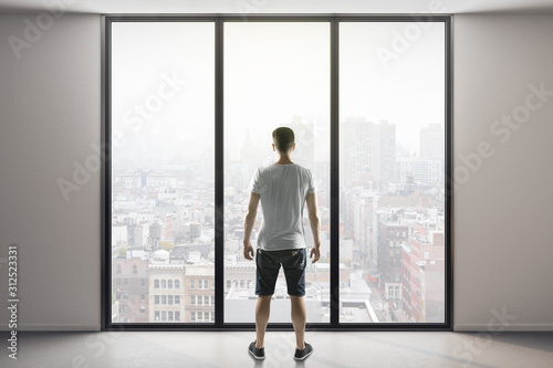 man in shorts standing in modern interior