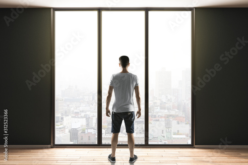 man in shorts standing in contemporary interior