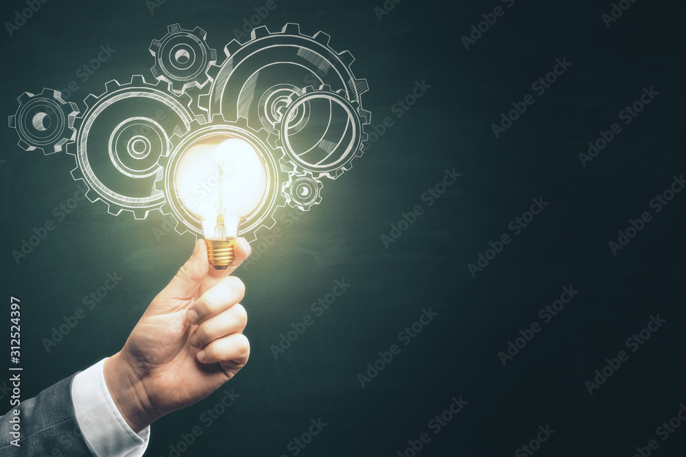 Businessman hand holding light bulb with gears Businessman hand holding light bulb with gears