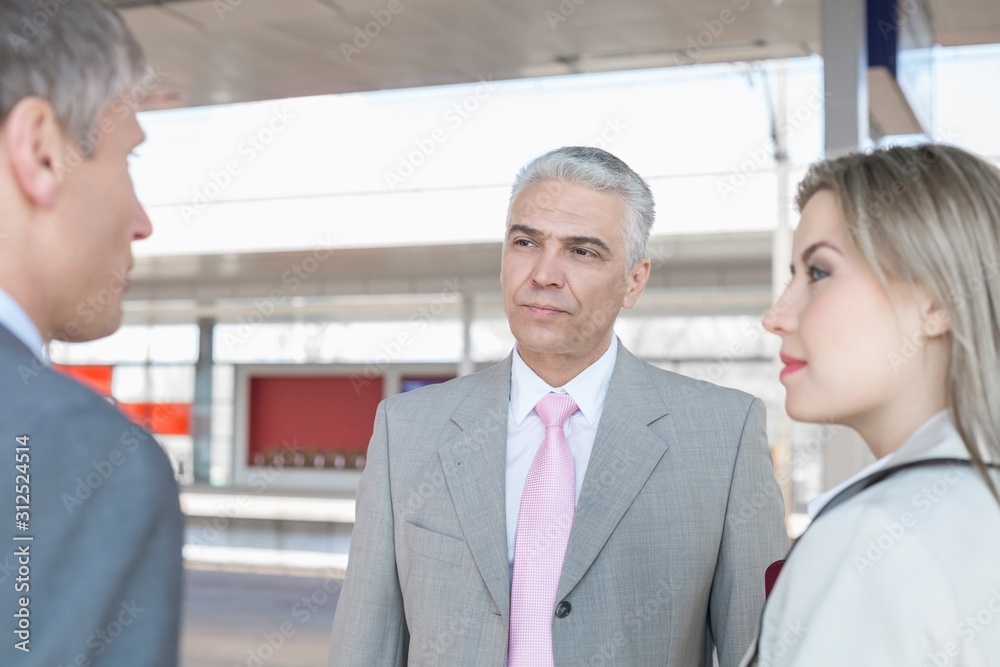 Businessman with colleagues on train platform
