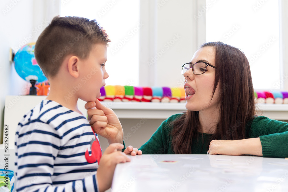 Children speech therapy concept. Preschooler practicing correct pronunciation with a female speech therapist.