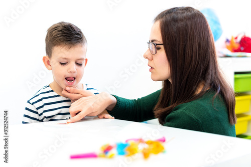 Children speech therapy concept. Preschooler practicing correct pronunciation with a female speech therapist. photo