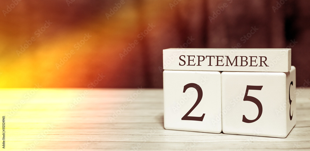 Calendar reminder event concept. Wooden cubes with numbers and month on September 25 with sunlight. Calendar reminder event concept. Wooden cubes with numbers and month on September 25 with sunlight.