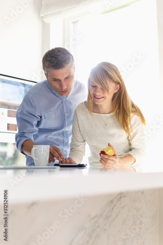 Father and daughter using tablet PC at home