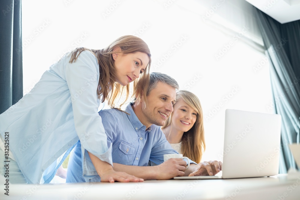 Happy parents with daughter using laptop at home Happy parents with daughter using laptop at home