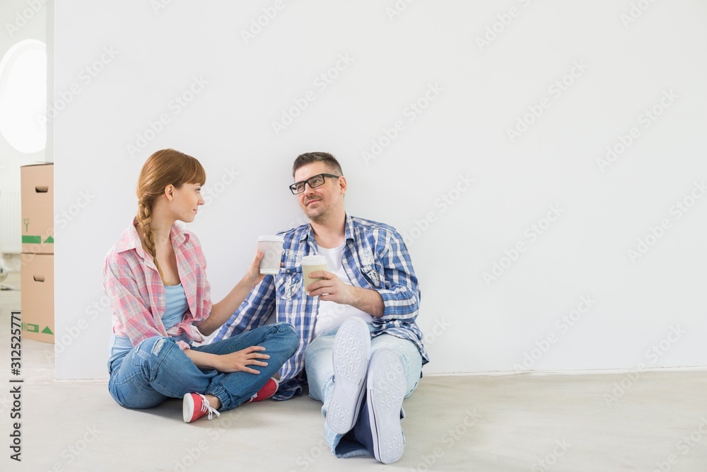 Full-length of couple having coffee in new house Full-length of couple having coffee in new house