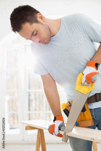 Man sawing wood in new house © moodboard