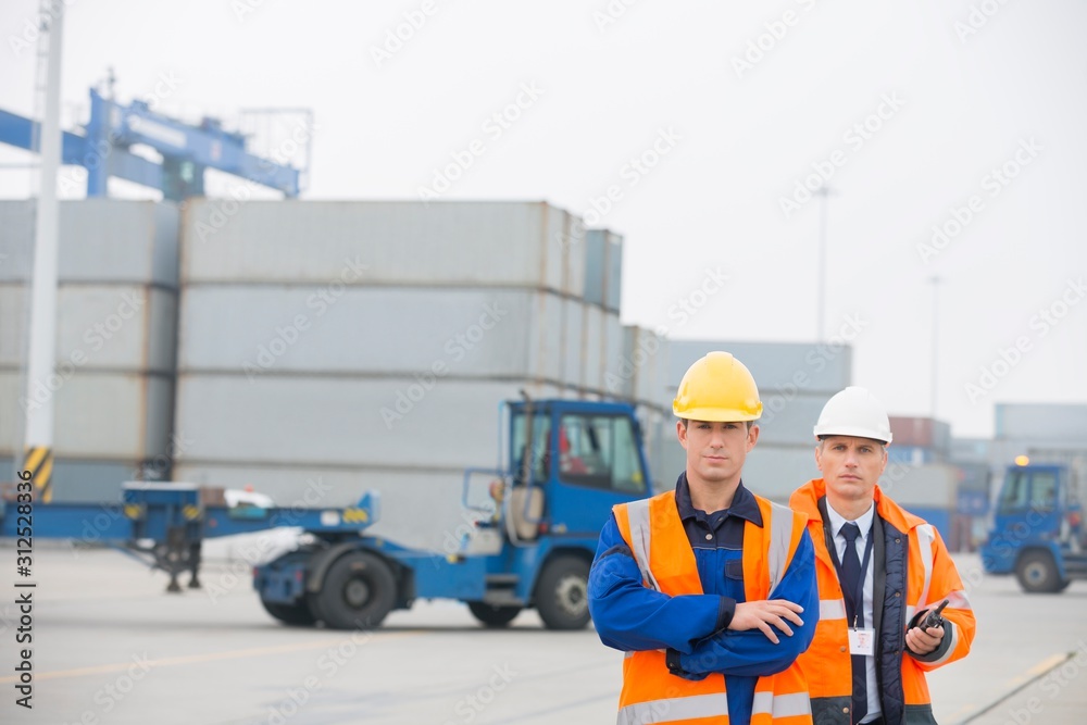 Portrait of confident workers standing in shipping yard Portrait of confident workers standing in shipping yard