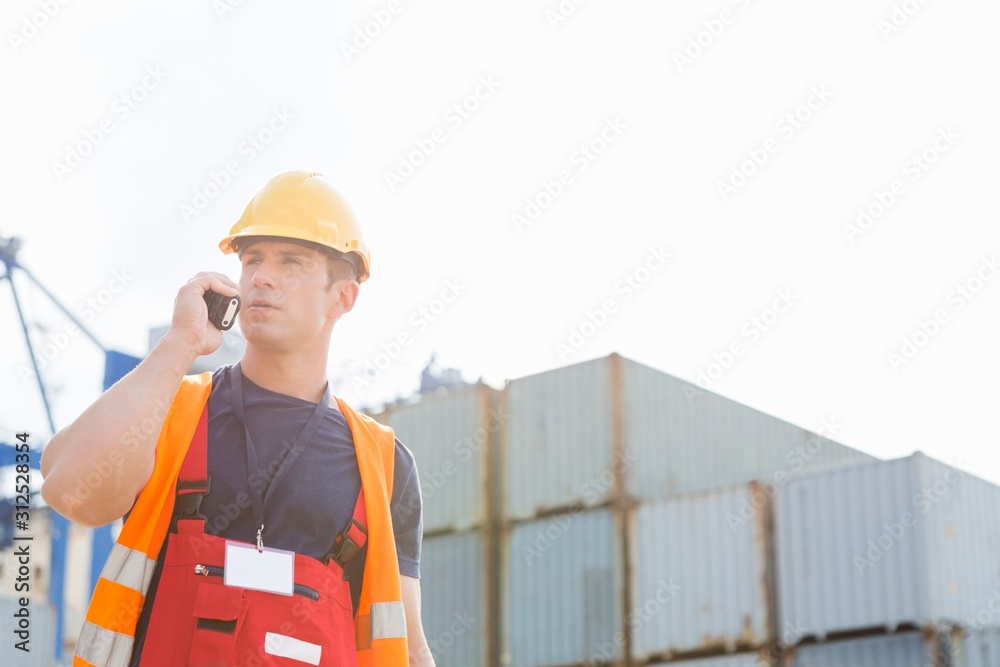 Male worker using walkie-talkie in shipping yard Male worker using walkie-talkie in shipping yard