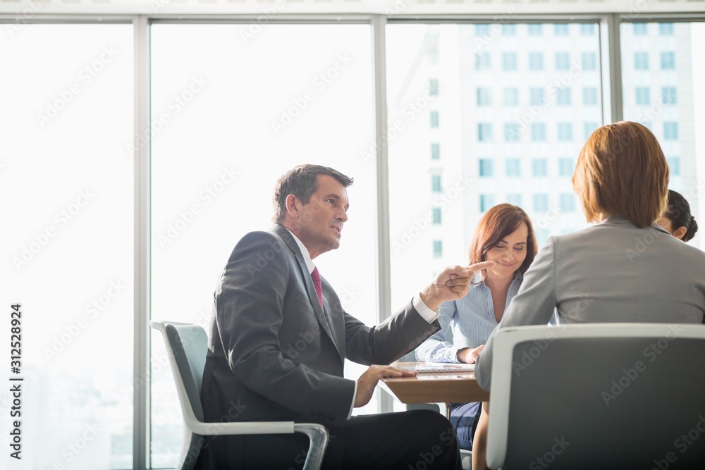 Businessman discussing with female team in conference room Businessman discussing with female team in conference room