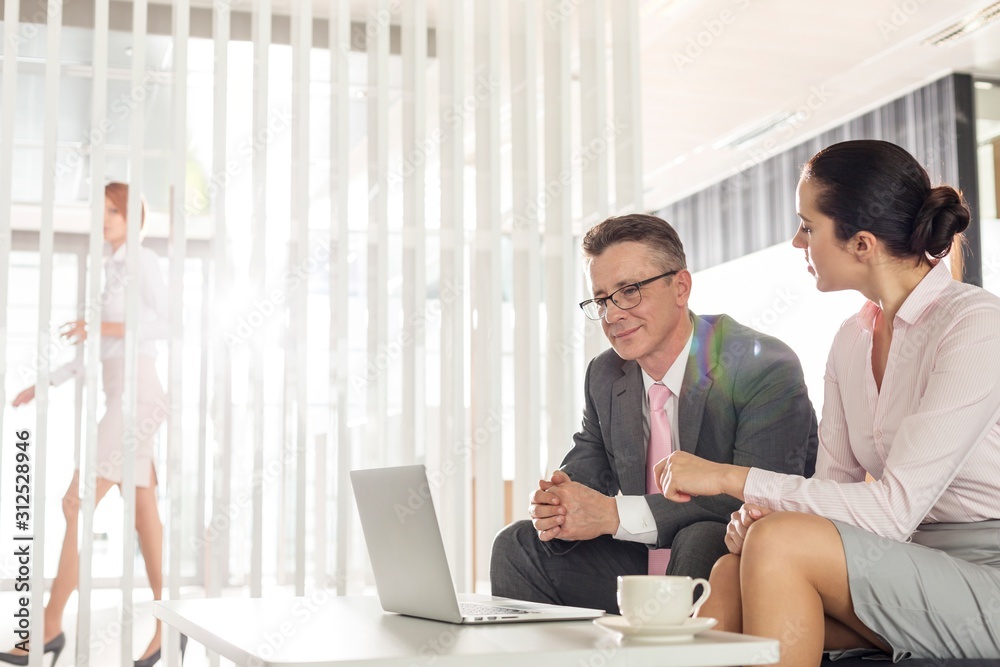 Businessman and businesswoman discussing in office Businessman and businesswoman discussing in office
