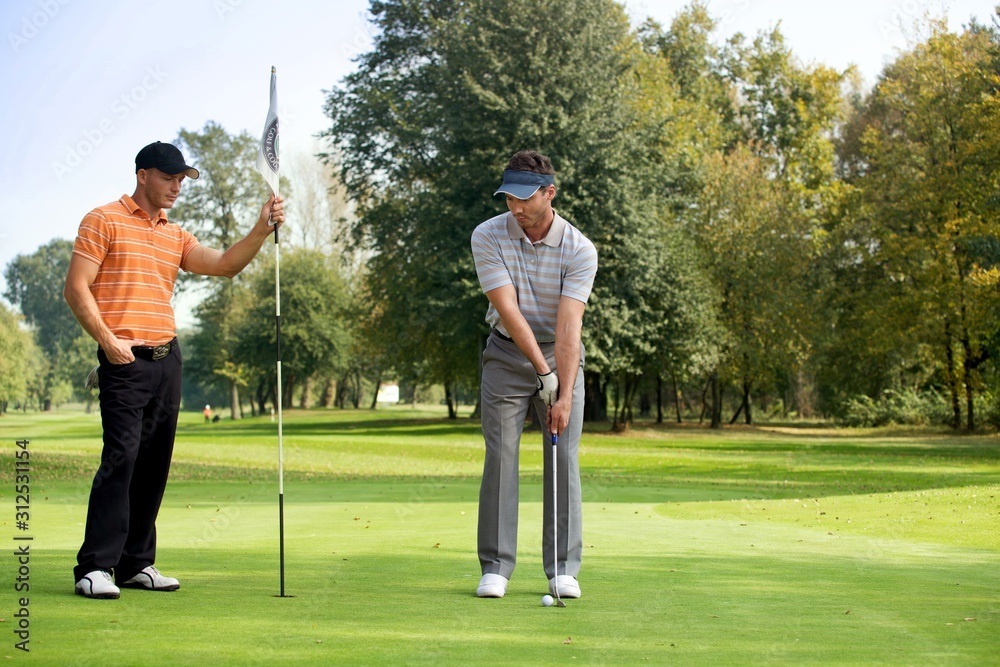 Young man with his friend playing golf in golf course