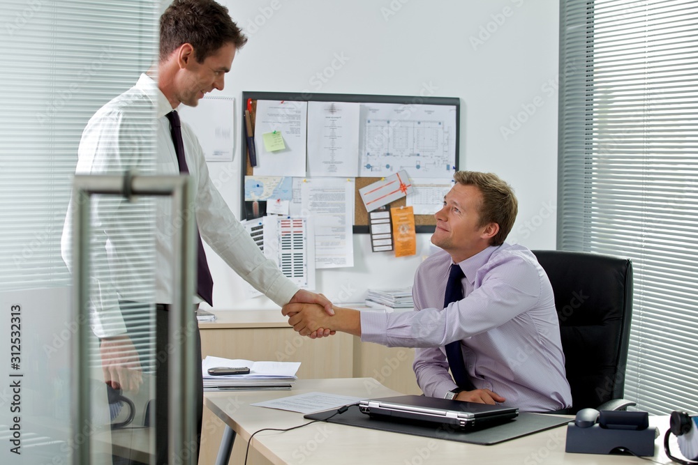 Two businessman shaking hands at office Two businessman shaking hands at office