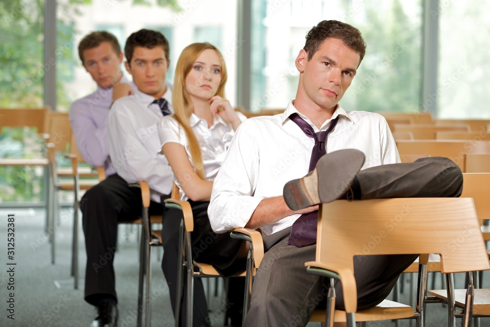 Business executives sitting in row at office