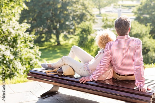 Middle-aged couple relaxing on park bench