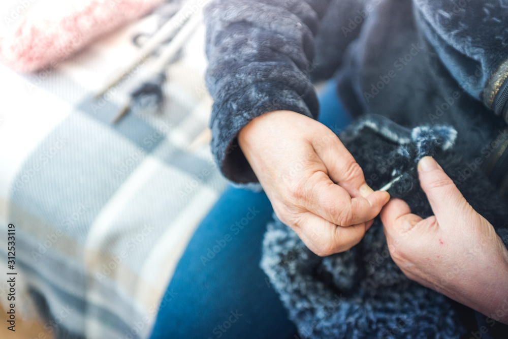 Close up photography of a knitting needle. Woman hands knitting a scarf.