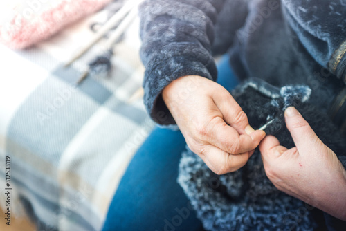 Close up photography of a knitting needle. Woman hands knitting a scarf. © JoseManuel