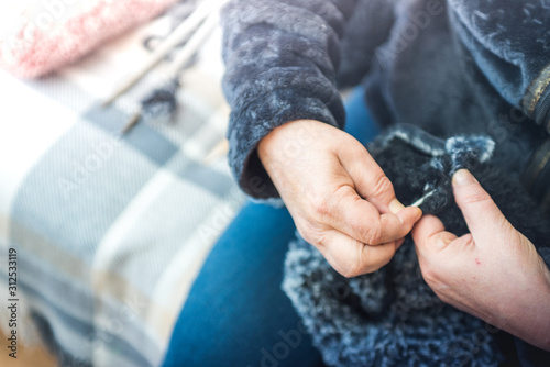 Close up photography of a knitting needle. Woman hands knitting a scarf.