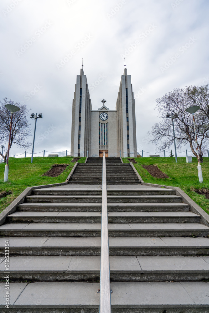 Vertical shot of church in Akureyri city in the northern part of Iceland. Stairs used as leading lines towards the church tower. Icelandic traveling, architecture and landmark concept.