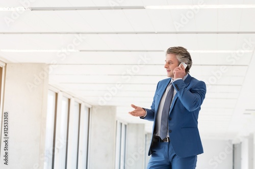 Wallpaper Mural Mature businessman talking on mobile phone in new office Torontodigital.ca