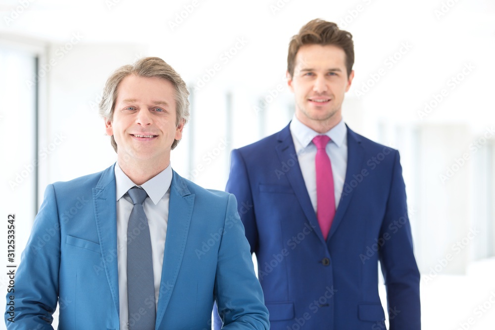Portrait of smiling mature businessman and male colleague in office Portrait of smiling mature businessman and male colleague in office