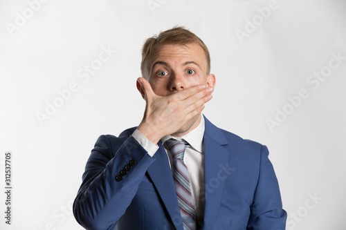Young businessman covering his mouth