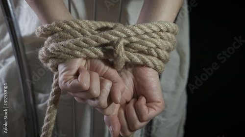 Violence against female. Women's hands are tied with a rope. Kidnapping.