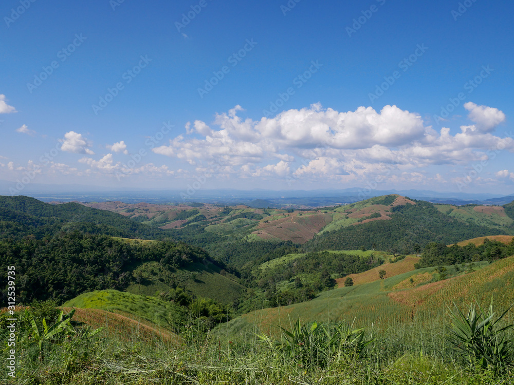 View of the sky and mountains. The mountains have been encroached upon as agricultural areas.