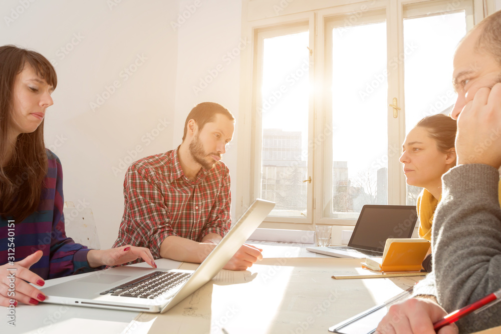 Team made of young architects in the sunny office. Team made of young architects in the sunny office.