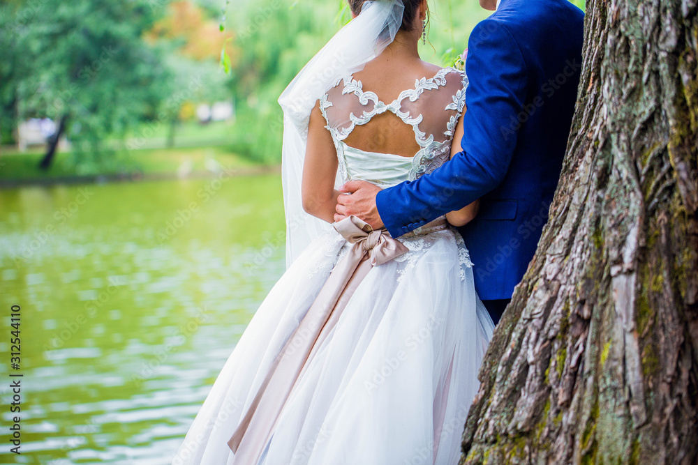 Wedding moment, couple of newlyweds looking at lake, on nature in the park. Wedding ceremony near lake. Wedding moment, couple of newlyweds looking at lake, on nature in the park. Wedding ceremony near lake.
