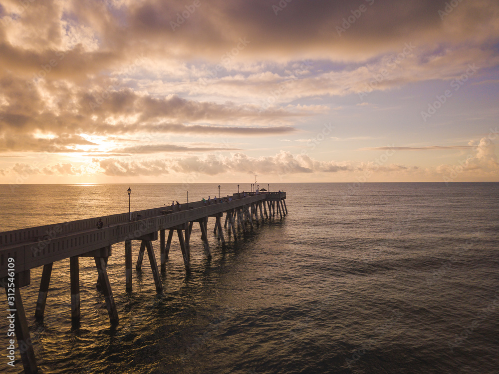 aerial view of Ocean and wooden pier at sunrise