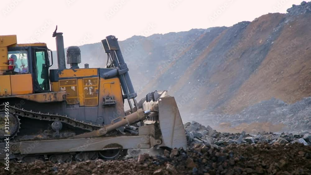 Yellow tracked bulldozer moves your bucket stones Yellow tracked bulldozer moves your bucket stones