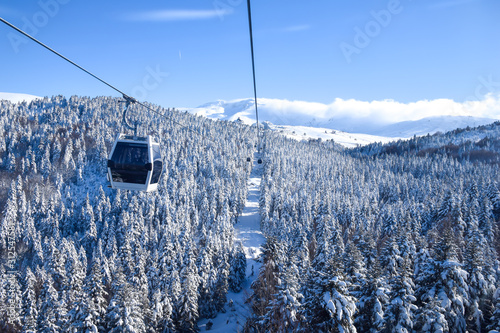 Transportation via cable car among snow covered tree on a sunny winter day in Uludag National Park